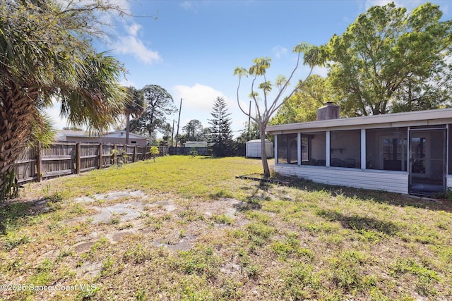 view of yard featuring a fenced backyard and a sunroom