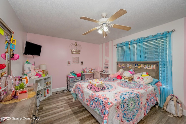 bedroom featuring ceiling fan, wood-type flooring, and a textured ceiling