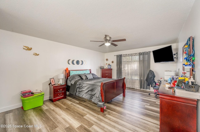 bedroom featuring ceiling fan, light hardwood / wood-style flooring, and a textured ceiling