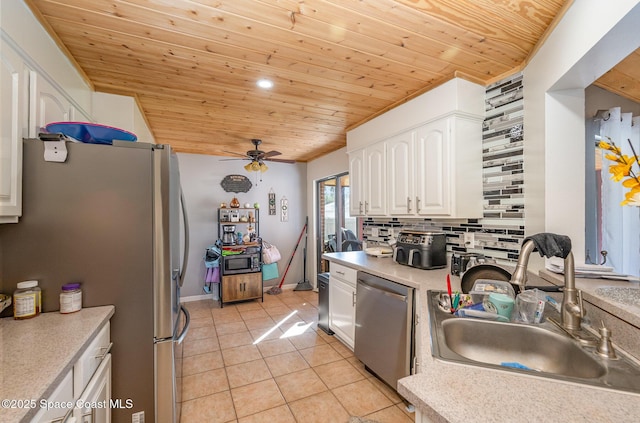 kitchen featuring light tile patterned flooring, tasteful backsplash, sink, white cabinets, and stainless steel appliances