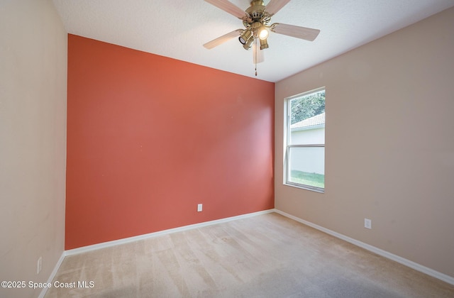 empty room with light carpet, a textured ceiling, and ceiling fan