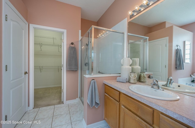 bathroom with tile patterned flooring, vanity, and walk in shower