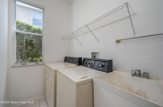 laundry area featuring independent washer and dryer, plenty of natural light, sink, and light tile patterned floors