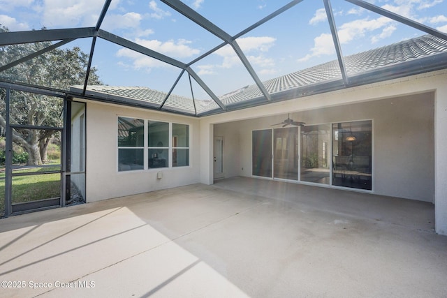 view of patio featuring ceiling fan and glass enclosure