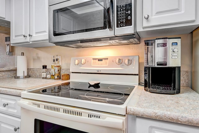 kitchen with white cabinetry and white range with electric stovetop