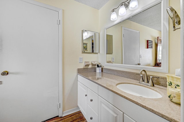 bathroom with vanity, hardwood / wood-style floors, and a textured ceiling