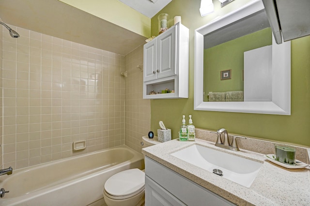 full bathroom featuring tiled shower / bath combo, vanity, and toilet