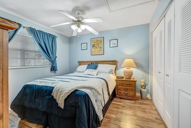 bedroom with ceiling fan, a textured ceiling, a closet, and light wood-type flooring