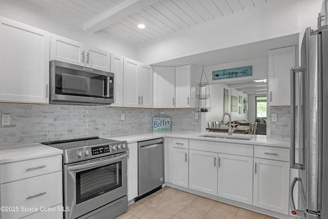 kitchen with sink, white cabinetry, tasteful backsplash, appliances with stainless steel finishes, and beam ceiling