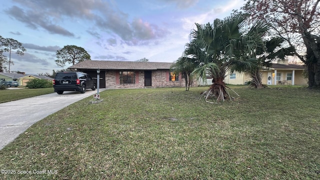 view of front of home featuring a yard, brick siding, and driveway