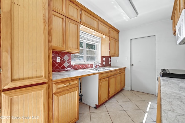 kitchen featuring tasteful backsplash, light tile patterned flooring, and sink