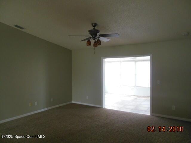 carpeted spare room with ceiling fan