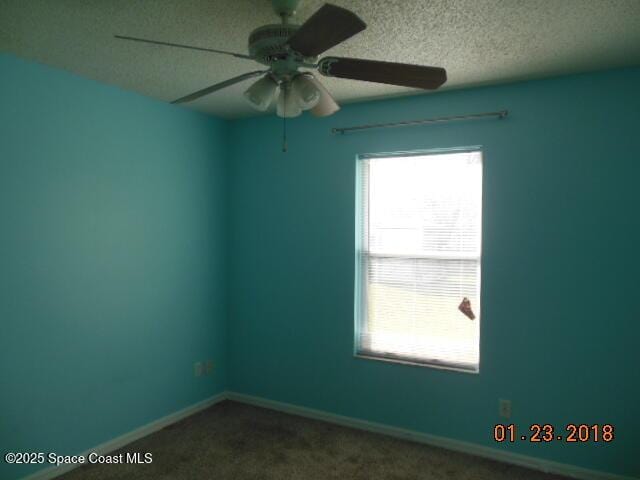 carpeted spare room featuring ceiling fan, a healthy amount of sunlight, and a textured ceiling