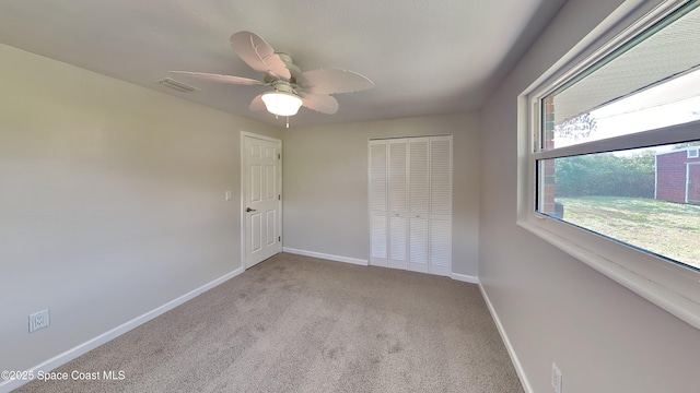 unfurnished bedroom with ceiling fan, light carpet, and a closet