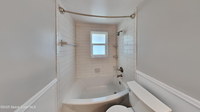 bathroom featuring tiled shower / bath combo and toilet