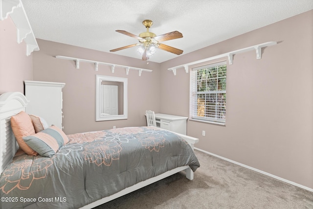 carpeted bedroom featuring ceiling fan, a textured ceiling, and baseboards