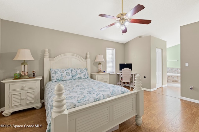 bedroom featuring baseboards, lofted ceiling, light wood-style floors, and a ceiling fan