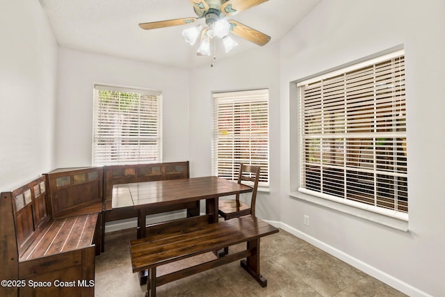 dining area with ceiling fan and baseboards