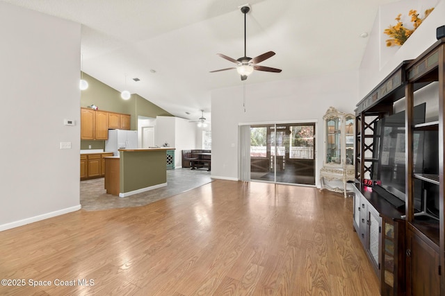 unfurnished living room with light wood-style flooring, baseboards, and high vaulted ceiling