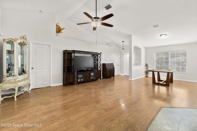 living room with wood finished floors, baseboards, visible vents, high vaulted ceiling, and ceiling fan