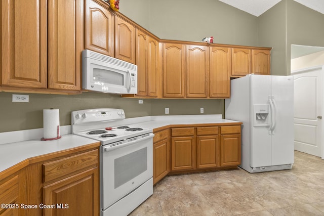 kitchen featuring white appliances, brown cabinetry, and light countertops