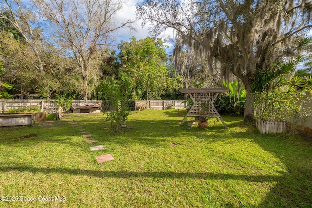 view of yard with a vegetable garden and a fenced backyard