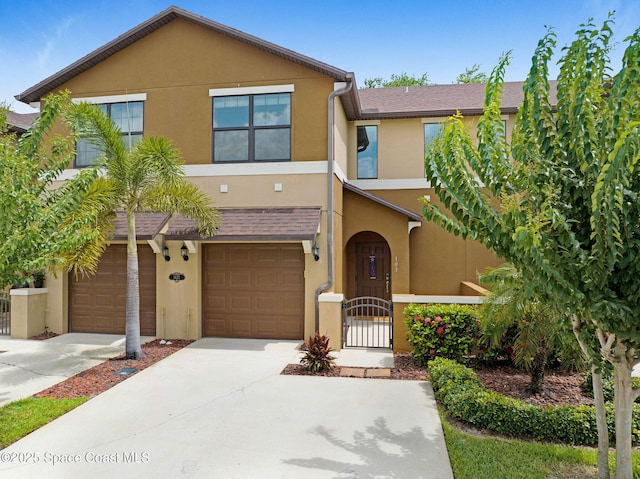 1425 Lara Cir Unit 103, Rockledge, FL 32955 - townhome / multi-family property featuring driveway, stucco siding, an attached garage, and a gate