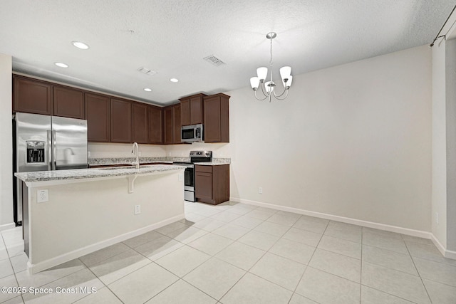 1425 Lara Cir Unit 103, Rockledge, FL 32955 - kitchen featuring appliances with stainless steel finishes, a chandelier, a center island with sink, recessed lighting, and light stone counters