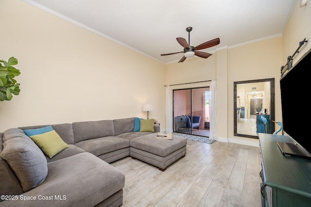 living area with ceiling fan, crown molding, light wood-style flooring, and a barn door