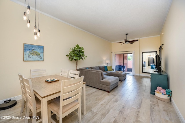 dining area with ornamental molding, light wood finished floors, a ceiling fan, and baseboards