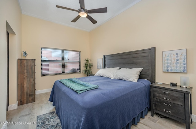 bedroom with baseboards, ceiling fan, light wood-style floors, and crown molding