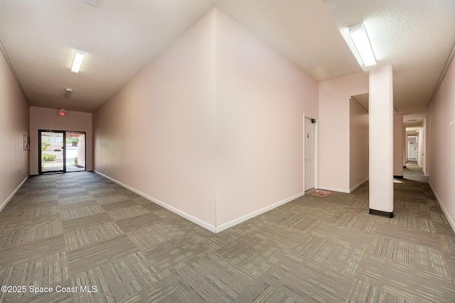 hall featuring carpet and baseboards