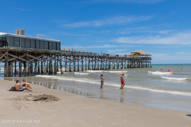 view of community with a water view, a view of the beach, and a pier