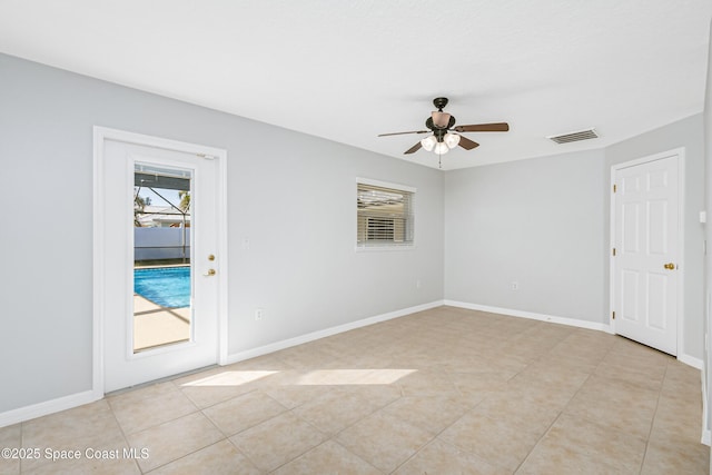 spare room featuring ceiling fan, light tile patterned floors, visible vents, and baseboards