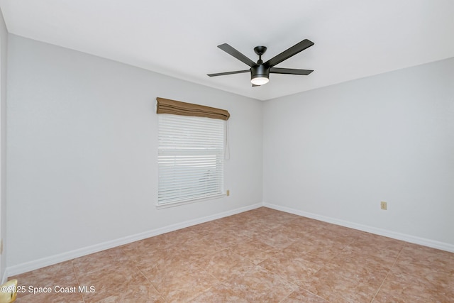 empty room featuring ceiling fan and baseboards