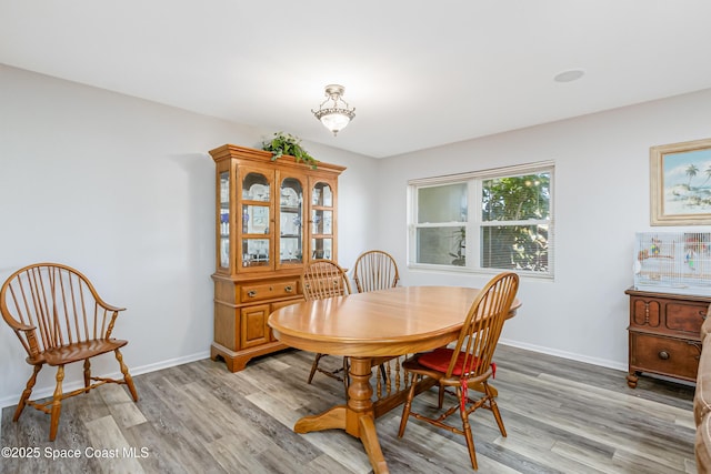 dining area with light wood-type flooring and baseboards