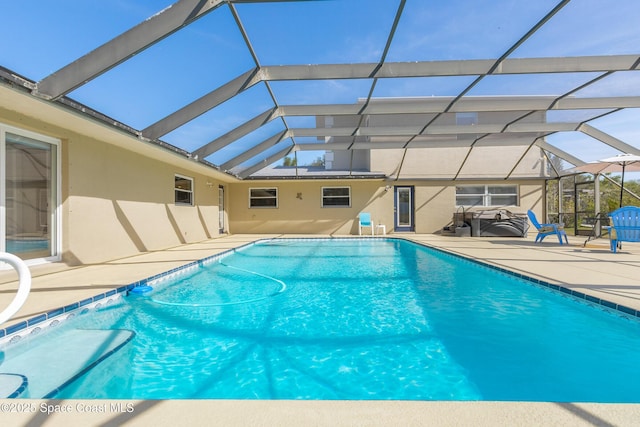 pool with glass enclosure and a patio