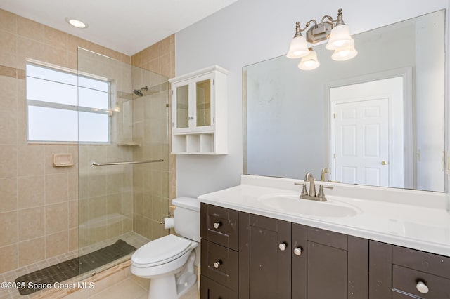 bathroom with tiled shower, vanity, and toilet