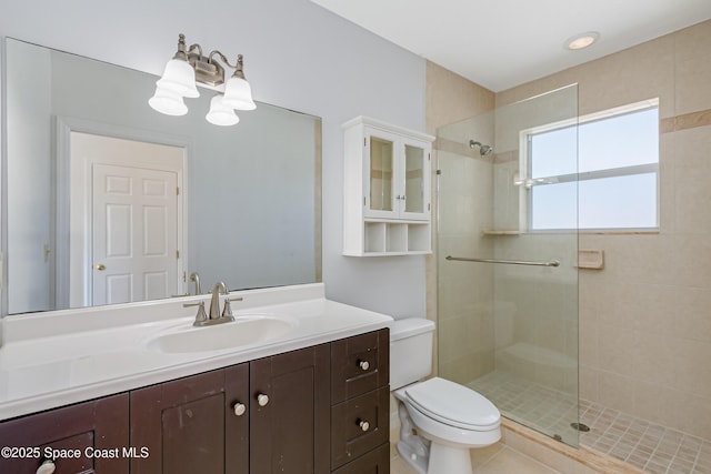 bathroom featuring tiled shower, vanity, and toilet