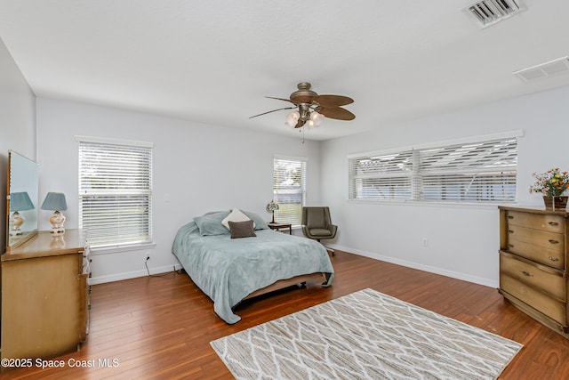 bedroom with baseboards, visible vents, ceiling fan, and hardwood / wood-style floors