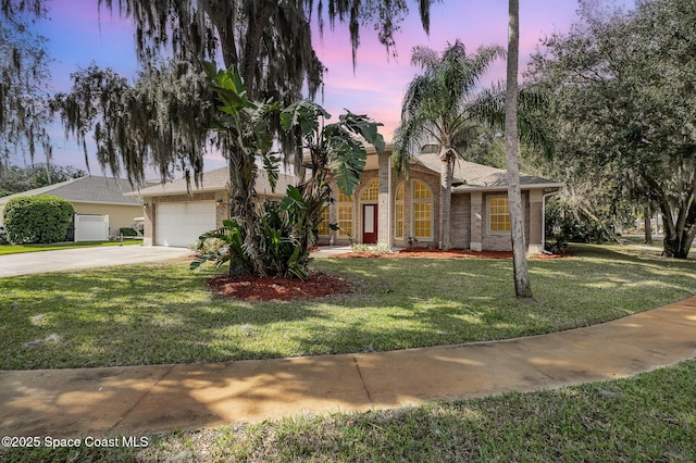 view of front of property with a garage and a yard