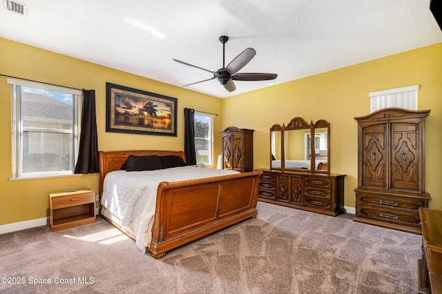 bedroom with lofted ceiling, light colored carpet, a textured ceiling, and ceiling fan