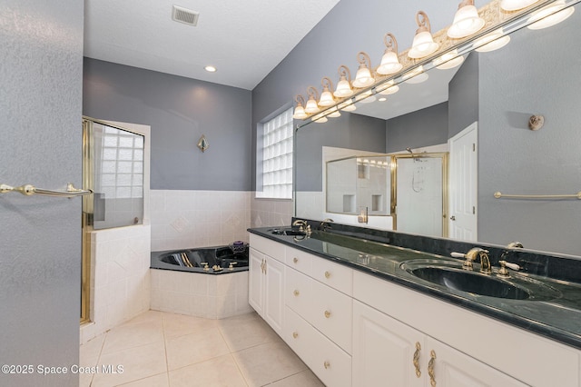 bathroom with tile patterned flooring, vanity, a healthy amount of sunlight, and separate shower and tub