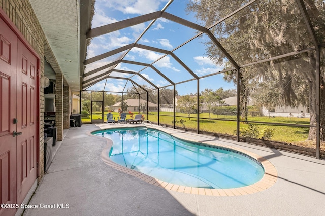 view of swimming pool featuring a yard, a patio area, and glass enclosure