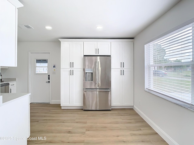 kitchen with white cabinetry, appliances with stainless steel finishes, and light hardwood / wood-style flooring