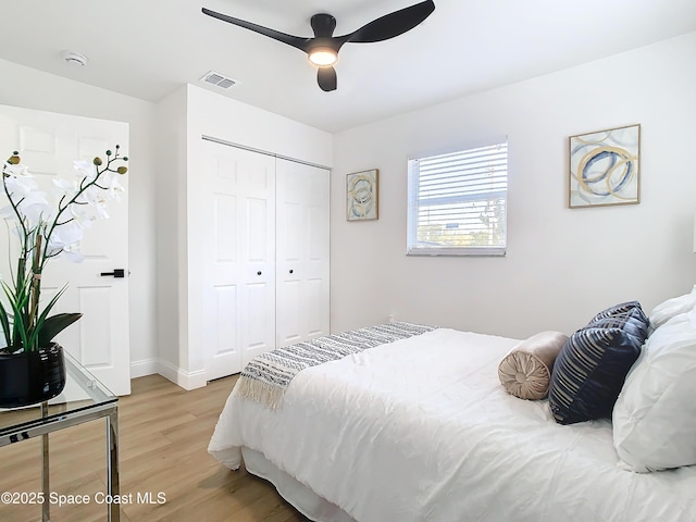 bedroom with ceiling fan, light hardwood / wood-style floors, and a closet