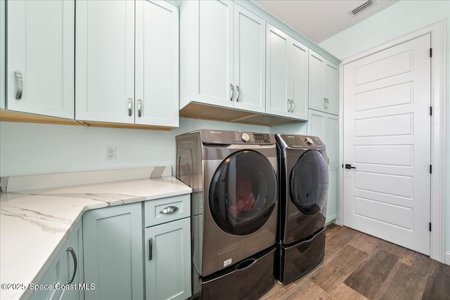 laundry area with cabinets, independent washer and dryer, and dark hardwood / wood-style floors