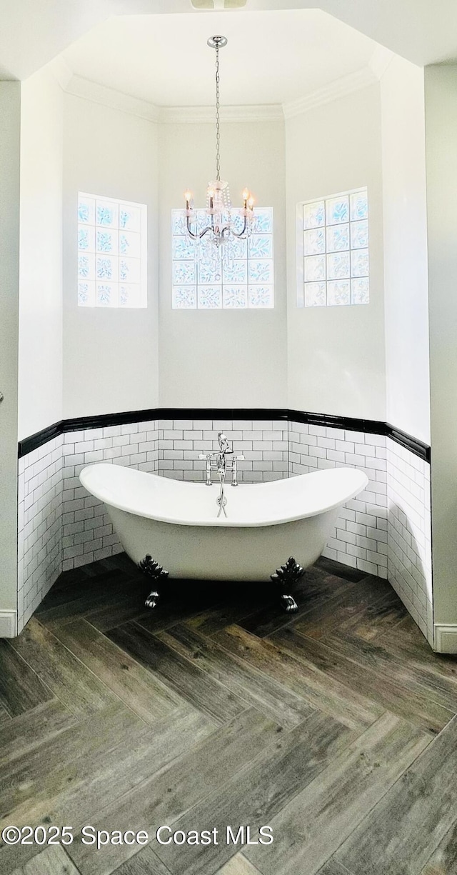 bathroom featuring tile walls, crown molding, parquet floors, and a bath