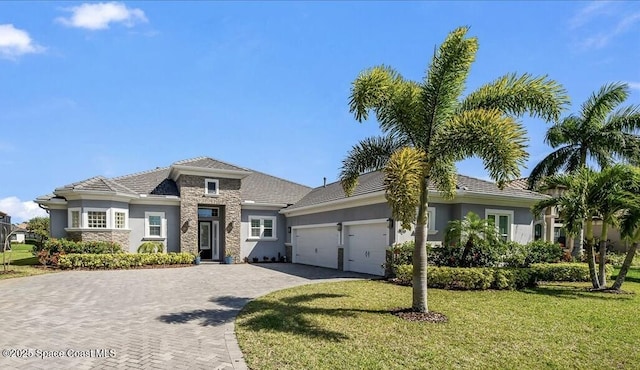 view of front of home with a front yard and a garage