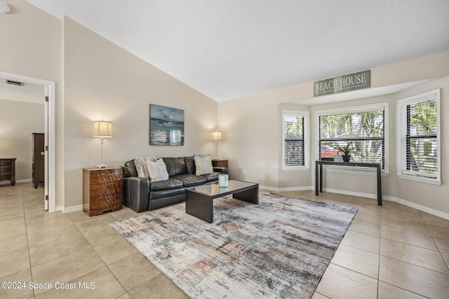 living room with light tile patterned floors, plenty of natural light, and high vaulted ceiling